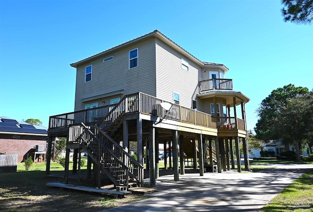 rear view of house with solar panels and a balcony