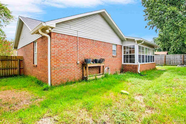 view of property exterior with a lawn and a sunroom