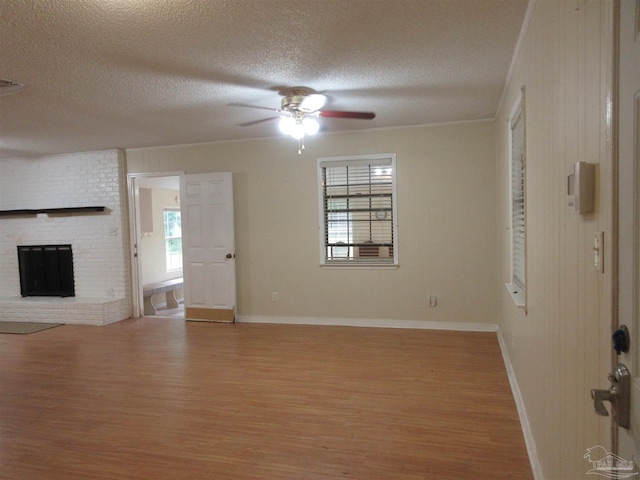 5078 Babb Ln, Pace, FL 32571 - unfurnished living room with light wood-style flooring, ceiling fan, a textured ceiling, and a fireplace