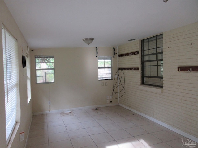 5078 Babb Ln, Pace, FL 32571 - tiled empty room with baseboards and brick wall