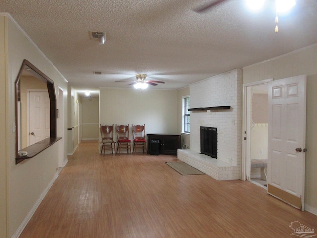 5078 Babb Ln, Pace, FL 32571 - unfurnished living room featuring ceiling fan, wood finished floors, a textured ceiling, and a fireplace