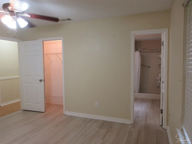 5078 Babb Ln, Pace, FL 32571 - unfurnished bedroom with a walk in closet, light wood-style flooring, a closet, and ceiling fan