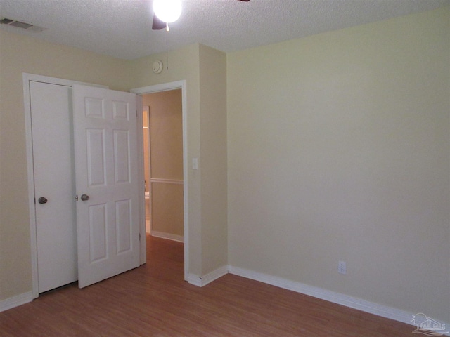 5078 Babb Ln, Pace, FL 32571 - spare room with wood finished floors, ceiling fan, a smoke detector, and a textured ceiling