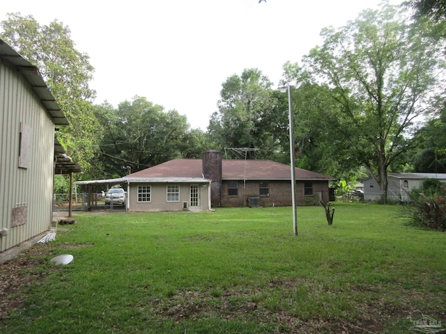 5078 Babb Ln, Pace, FL 32571 - back of property featuring a lawn, a chimney, and view of scattered trees