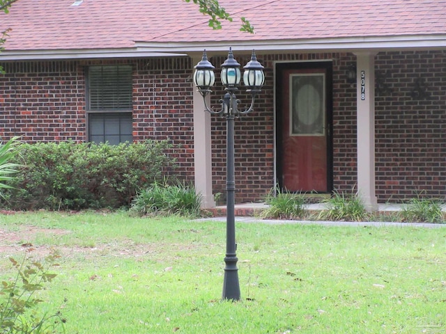 5078 Babb Ln, Pace, FL 32571 - doorway to property featuring brick siding, roof with shingles, and a lawn