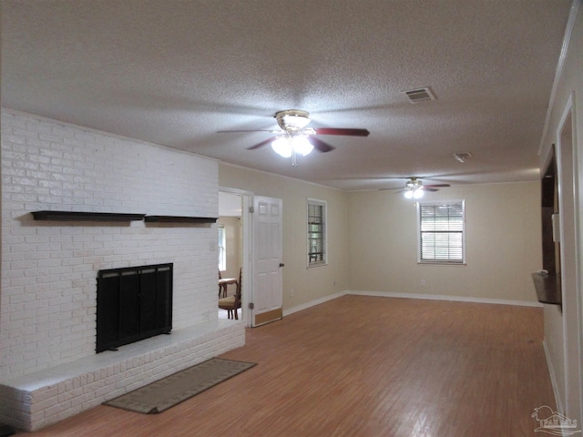 5078 Babb Ln, Pace, FL 32571 - unfurnished living room with a ceiling fan, wood finished floors, a brick fireplace, and a textured ceiling