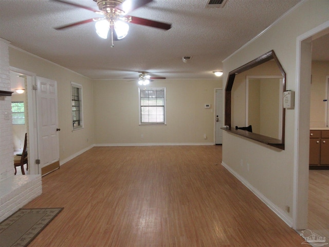 5078 Babb Ln, Pace, FL 32571 - spare room with a ceiling fan, light wood-style floors, a textured ceiling, and a brick fireplace