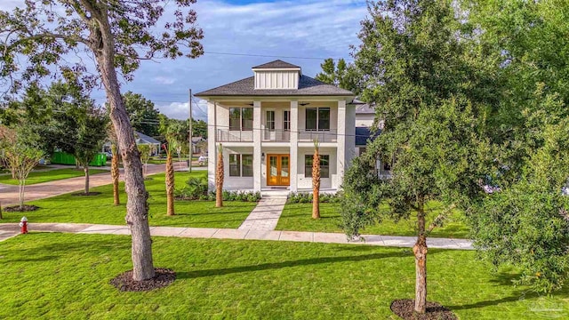 view of front facade featuring french doors, a balcony, and a front yard