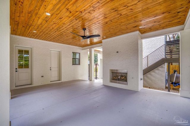 view of patio with an outdoor brick fireplace and ceiling fan