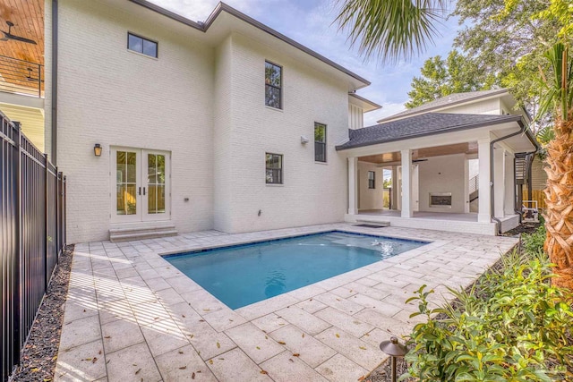 rear view of property featuring french doors, a fenced in pool, ceiling fan, and a patio area