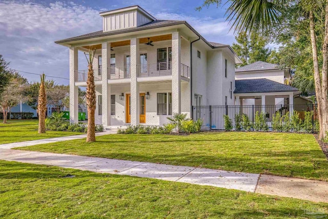 view of front facade featuring a balcony, a front yard, and ceiling fan