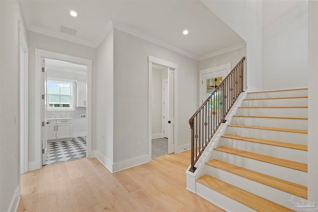 stairway featuring crown molding and hardwood / wood-style floors