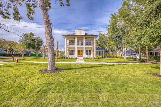 view of front of home with a balcony and a front lawn