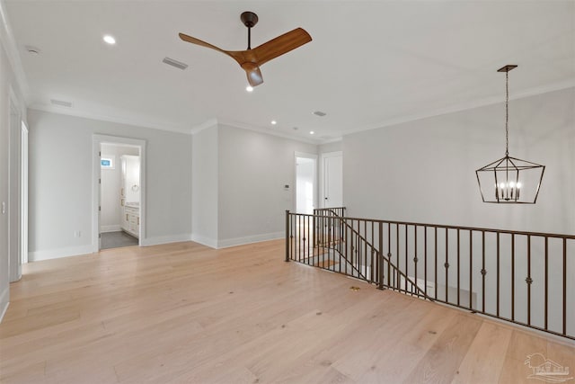 unfurnished room with crown molding, ceiling fan with notable chandelier, and light hardwood / wood-style floors