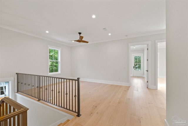 unfurnished room featuring a wealth of natural light, ornamental molding, light hardwood / wood-style floors, and ceiling fan