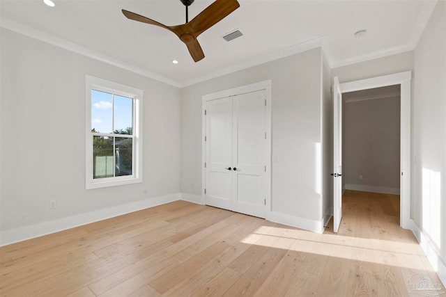 unfurnished bedroom featuring ornamental molding, light hardwood / wood-style floors, ceiling fan, and a closet