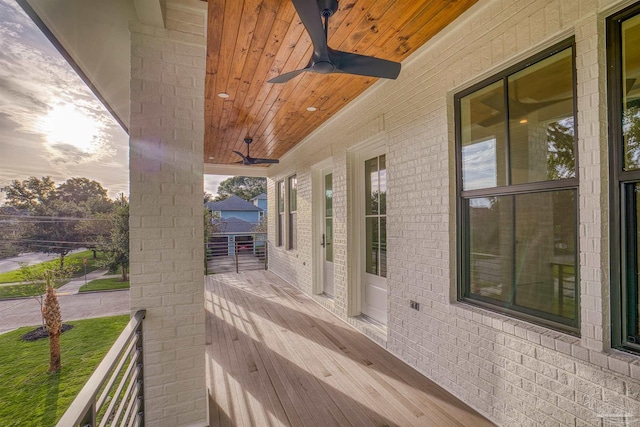 deck at dusk featuring ceiling fan and covered porch