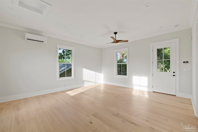 unfurnished room featuring crown molding, light hardwood / wood-style flooring, a wall unit AC, and a wealth of natural light