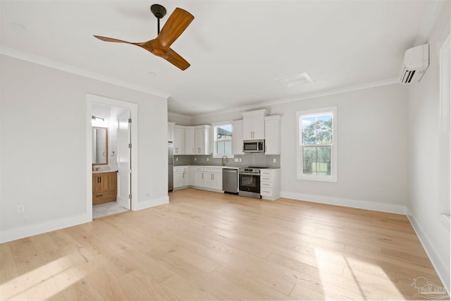 unfurnished living room with sink, crown molding, an AC wall unit, and light wood-type flooring