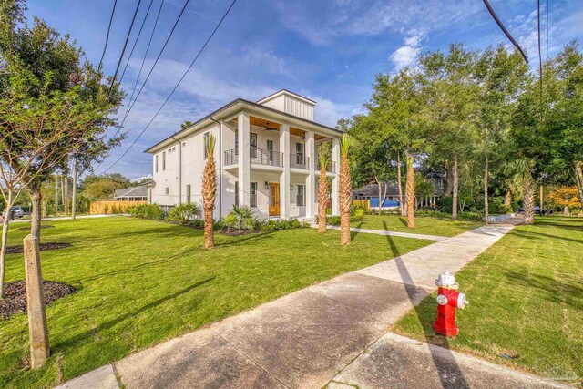 view of front of property with a balcony and a front lawn