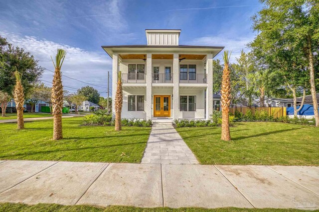 view of front of property with a front yard, french doors, and a balcony