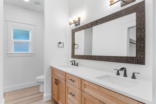 bathroom featuring toilet, hardwood / wood-style flooring, and vanity