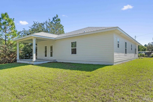 rear view of property featuring a patio and a lawn