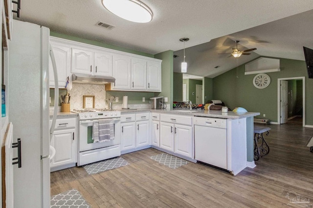 kitchen with hanging light fixtures, kitchen peninsula, white cabinetry, white appliances, and ceiling fan