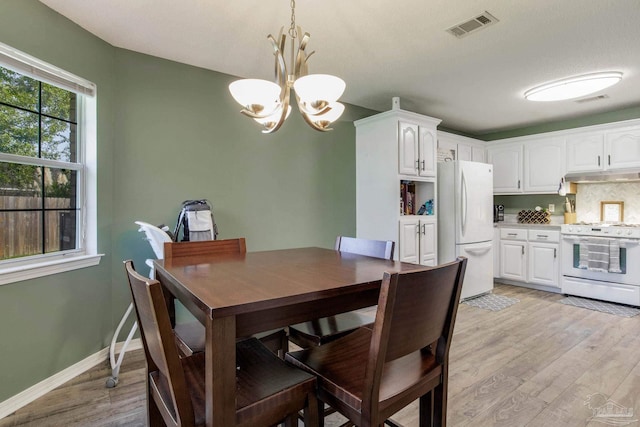 dining room featuring light hardwood / wood-style flooring and an inviting chandelier