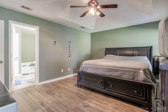 bedroom with ensuite bathroom, light wood-type flooring, and ceiling fan