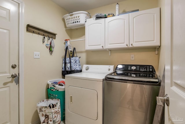 laundry area with washer and dryer and cabinets