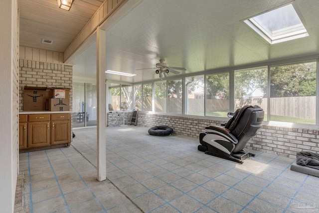 sunroom / solarium featuring ceiling fan and a skylight