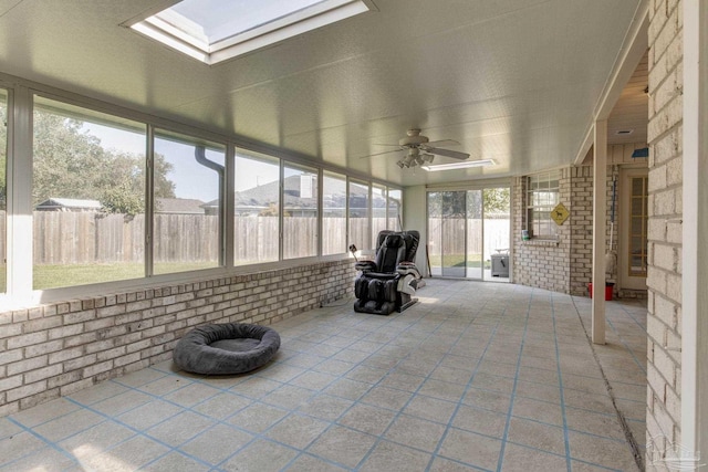 unfurnished sunroom featuring ceiling fan and a skylight