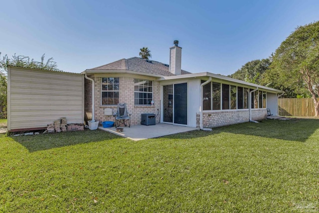 rear view of property with a patio, a sunroom, and a lawn