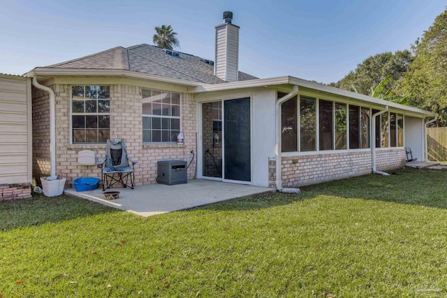 back of property featuring a sunroom, a lawn, and a patio area