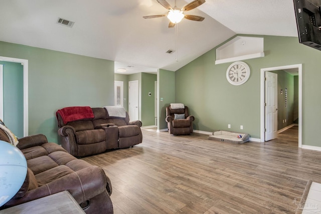 living room with ceiling fan, vaulted ceiling, and light hardwood / wood-style flooring