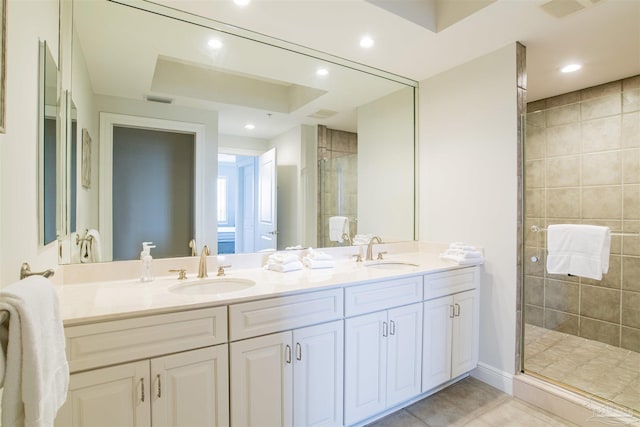 full bath featuring double vanity, recessed lighting, a sink, and a shower stall