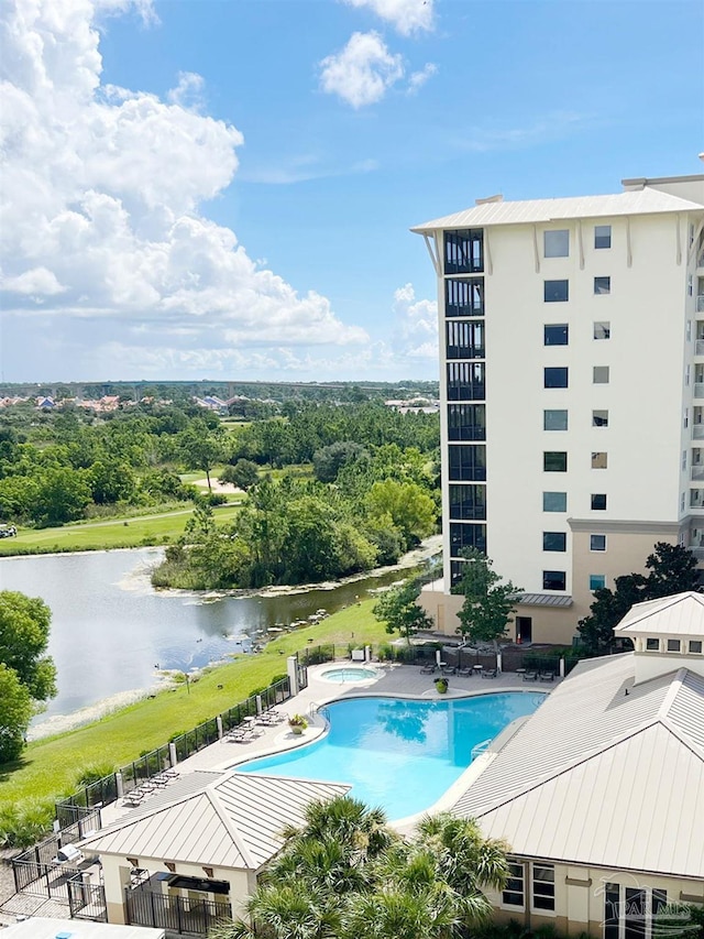 community pool with a water view, a patio area, and a community hot tub