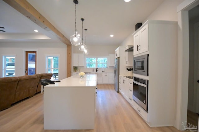 kitchen featuring light hardwood / wood-style flooring, white cabinets, stainless steel appliances, and a center island