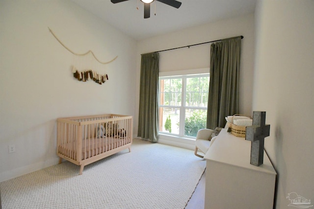 bedroom featuring carpet, lofted ceiling, a crib, and ceiling fan