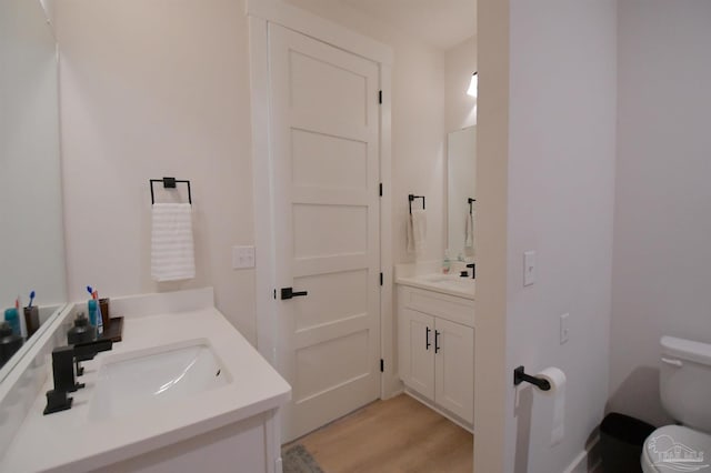 bathroom featuring toilet, vanity, and hardwood / wood-style flooring