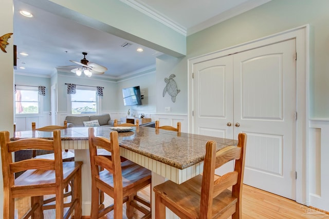 dining room with ceiling fan, crown molding, and light hardwood / wood-style floors