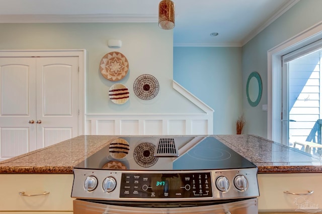 kitchen featuring crown molding, stainless steel stove, and a wealth of natural light