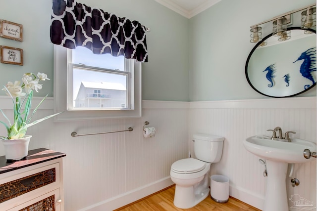 bathroom featuring ornamental molding, hardwood / wood-style flooring, and toilet