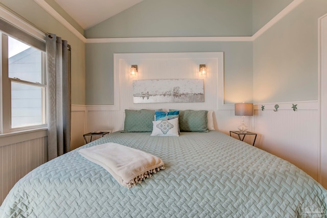 bedroom with vaulted ceiling and multiple windows