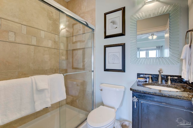 bathroom with vanity, a shower with shower door, and toilet