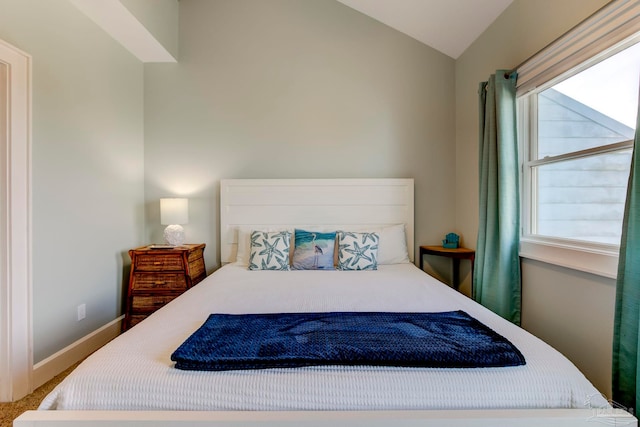 bedroom featuring multiple windows, vaulted ceiling, and carpet floors