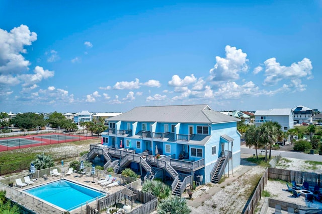 rear view of house with a community pool