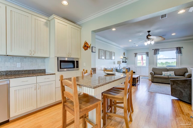 dining area featuring ornamental molding, ceiling fan, and light hardwood / wood-style flooring