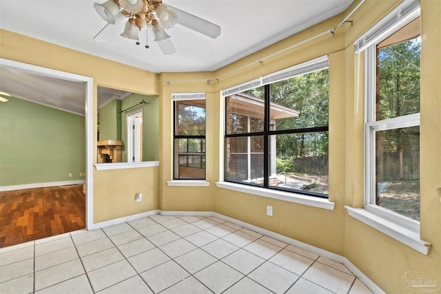 unfurnished sunroom with ceiling fan and a wealth of natural light